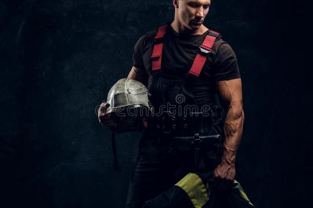 野蛮的消防队员相貌斜着和保存一头盔采用他的h和