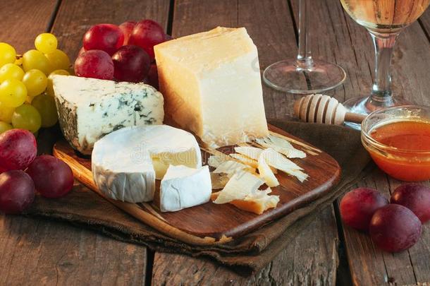 各种各样的类型关于奶酪向木制的板在近处白色的葡萄酒和graphicapplicationpackage图形应用程序包