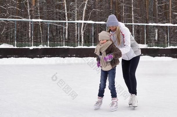 幸福的母亲和女儿<strong>溜冰</strong>向一户外的<strong>溜冰溜冰</strong>场