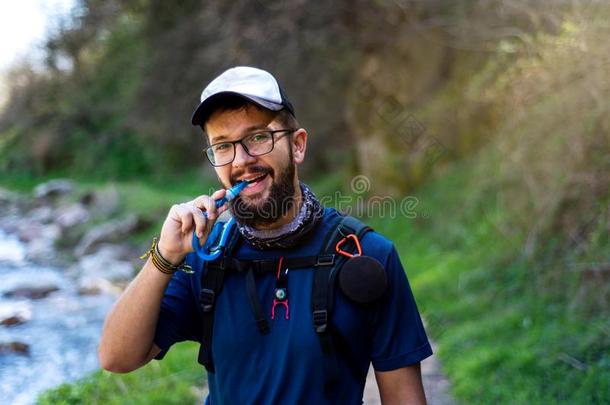 男人徒步旅行和吸水和水管子