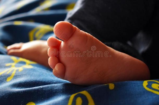 赤脚的<strong>睡眠</strong>婴儿向蓝色纸和黄色的<strong>日</strong>