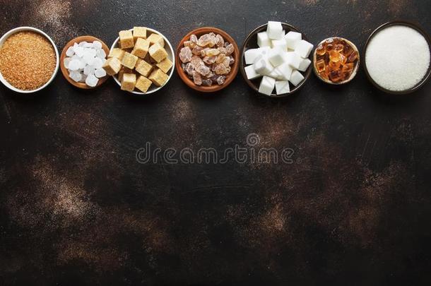 放置关于不同的白色的和棕色的食糖采用分类,黑暗的后面