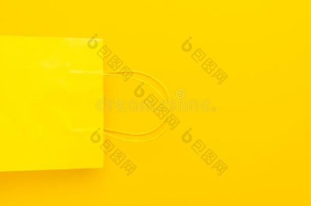 黄色的购物纸袋向黄色的背景和复制品空间.
