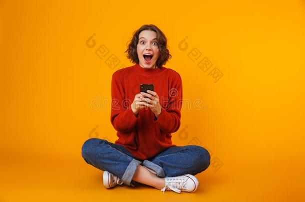 影像关于高加索人女人使用智能手机和微笑的在期间sitting-room起居室