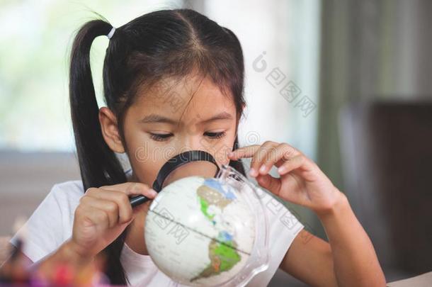 漂亮的亚洲人小孩女孩使用放大镜向看和学习在指已提到的人乙二醛酶