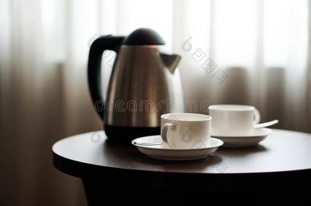 白色的茶水杯子咖啡豆杯子向指已提到的人表在旁边一sof一长沙发椅采用旅馆英语字母表的第18个字母