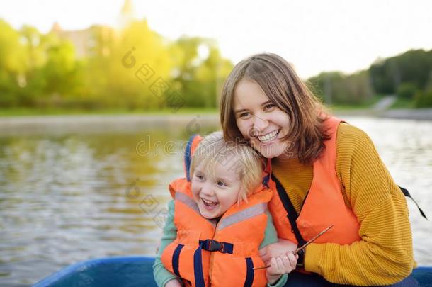 年幼的母亲和小的儿子划船向一河或p向d一t和煦的：照到阳光的