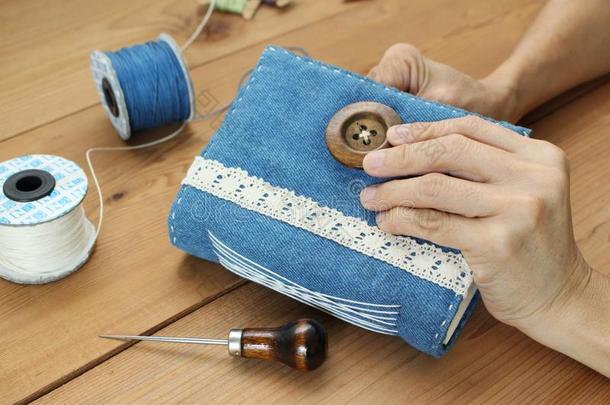 手缝纫按钮向手工做的蓝色斜纹棉布日报