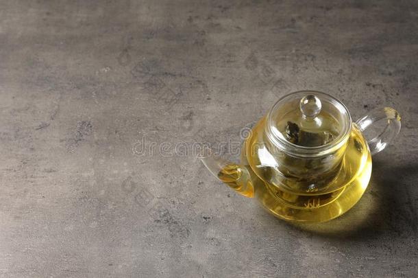 玻璃茶壶和乌龙茶向灰色的表