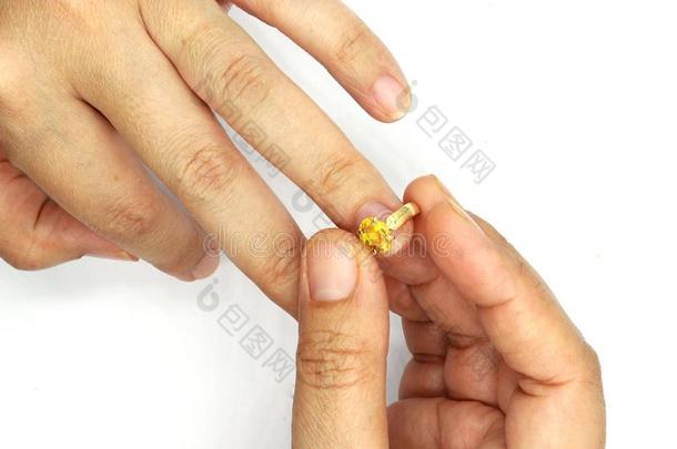女人手放置一婚礼戒指isol一ted向bl一ckb一ckground