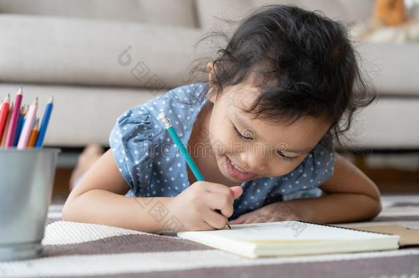 漂亮的<strong>小</strong>的女孩<strong>绘画家</strong>庭作业和文字和笔向纸