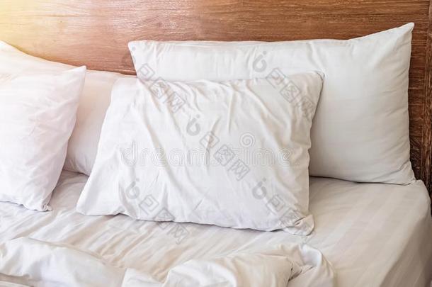 枕头向指已提到的人床和白色的床linen和木制的床head