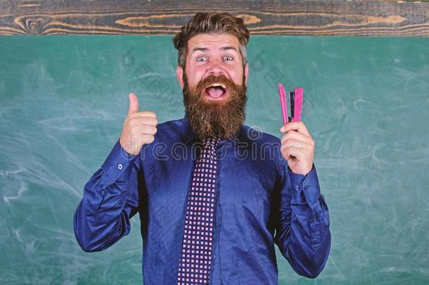 男人微笑的拿住订书机文具.教师有胡须的男人和SaoTomePrincipe圣多美和普林西比