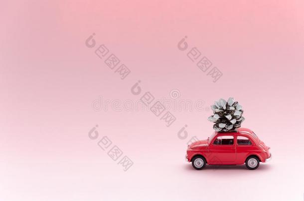 红色的制动火箭玩具模型汽车和圣诞节松树圆锥体向粉红色的后座议员