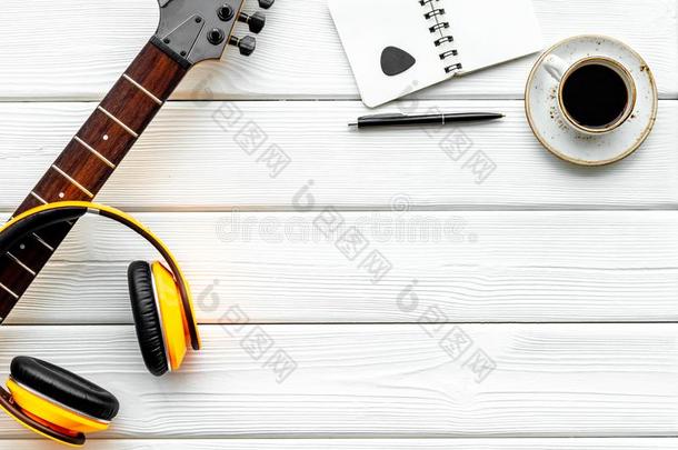 音乐家使工作位和吉他,耳机,笔记簿和咖啡豆