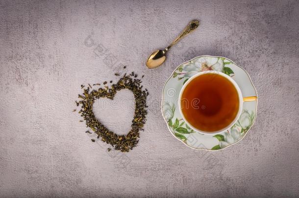 杯子关于黑的茶水,小的古老的勺和心-合适的分散的