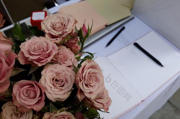 花束关于美丽的粉<strong>红色</strong>的玫瑰和<strong>签名</strong>书和笔