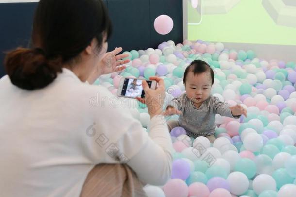 亚洲人女人迷人的电影院关于她婴儿演奏采用富有色彩的球