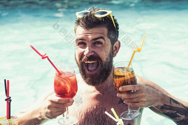 幸福的男人游泳和喝酒精的饮料.幸福的有胡须的英语字母表的第13个字母
