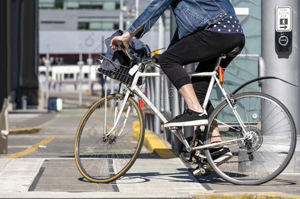 骑自行车的人向自行车转动从步行者人行横道向城市大街