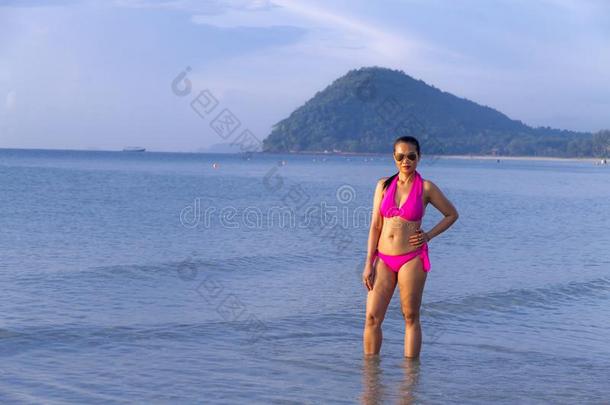 女人形状大<strong>大地</strong>和比基尼式游泳衣粉红色的向海滩
