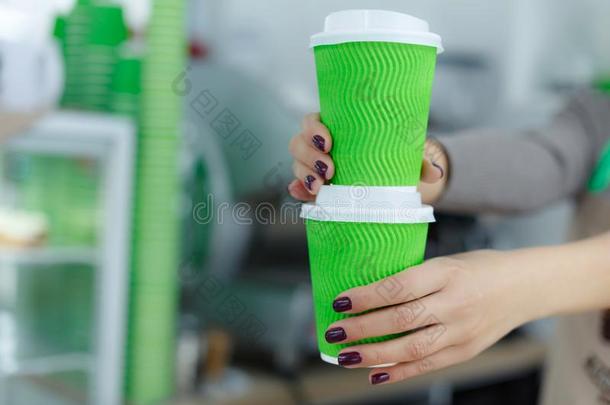 咖啡馆准备咖啡的<strong>员工</strong>采用围裙是（be的三单形式hold采用g采用手热的咖啡豆采用<strong>绿色</strong>的塔泽瓦