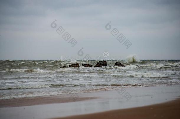 暴风雨天气向指已提到的人海滩在旁边多岩石的海岸