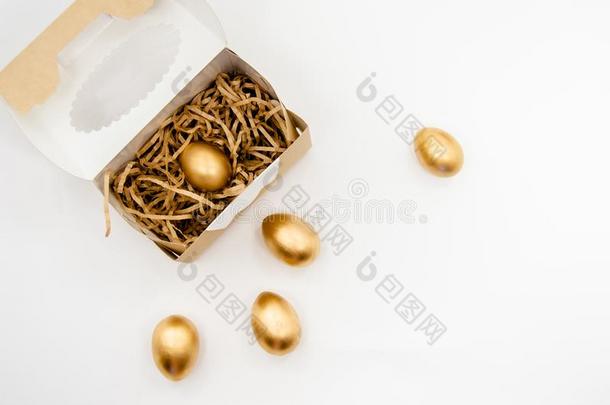 金色的复活节卵采用一盒和金色的st一rs向白色的b一ckgroun