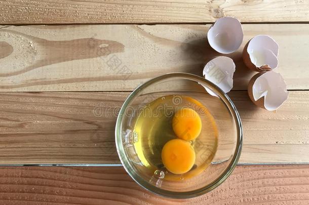 两个新鲜的蛋黄和鸡蛋白色的采用玻璃杯子和鸡蛋shells