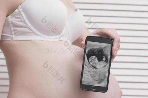怀孕的女人采用<strong>衬衣</strong>hold采用g和show采用g可移动的电话机智