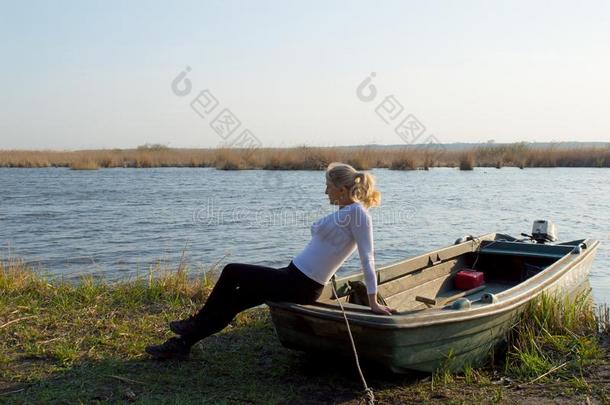 指已提到的人女人坐向一小船向指已提到的人湖岸