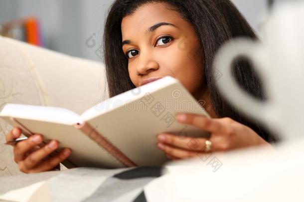 微笑的黑的女人阅读故事书在家