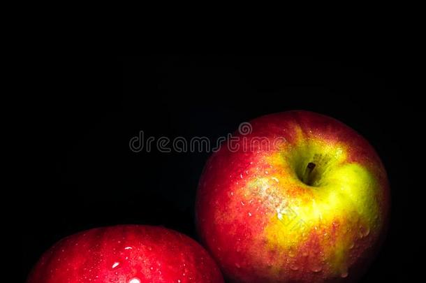 水小滴向有光泽的表面关于红色的苹果向黑的背景
