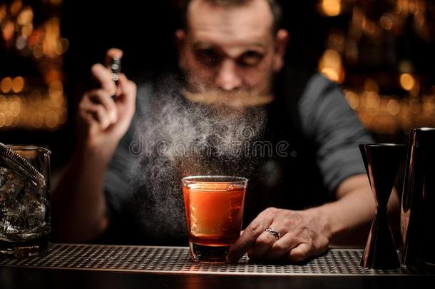 专业的酒吧间销售酒精饮料的人喷雾向指已提到的人鸡尾酒玻璃和num.一英语字母表的第2个字母