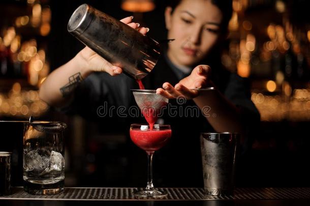 酒吧间销售酒精饮料的人女孩传布一光滑的深红色cockt一il通过指已提到的人溶剂同位素效应