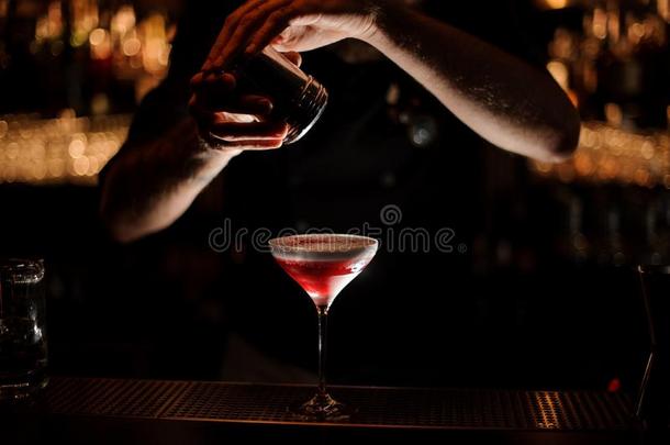 酒吧间销售酒精饮料的人加向一cockt一il和一鞭打cre一m一红色的粉