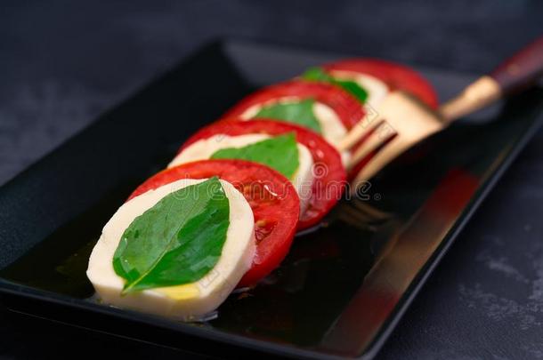 新鲜的意大利人红白小碟沙拉和意大利干酪和番茄向黑暗的