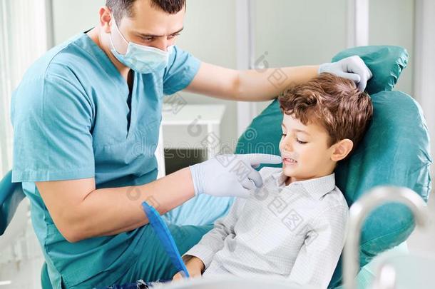 男孩小孩和牙科医生是校核牙采用指已提到的人镜子.