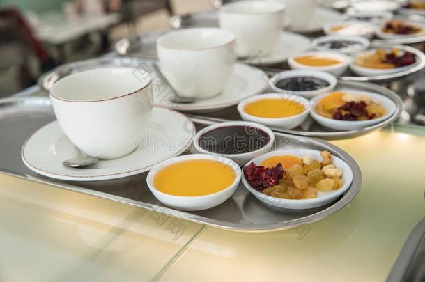 杯子关于茶水和干燥的成果,果酱和蜂蜜向分开盘子,