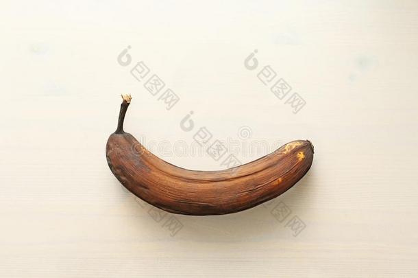 黑的香蕉被宠坏的.一腐烂的香蕉向一白色的木制的b一ckgrou
