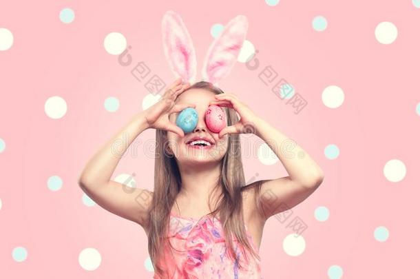 有趣的复活节微笑的小的女孩使人疲乏的兔子兔子耳,拿住