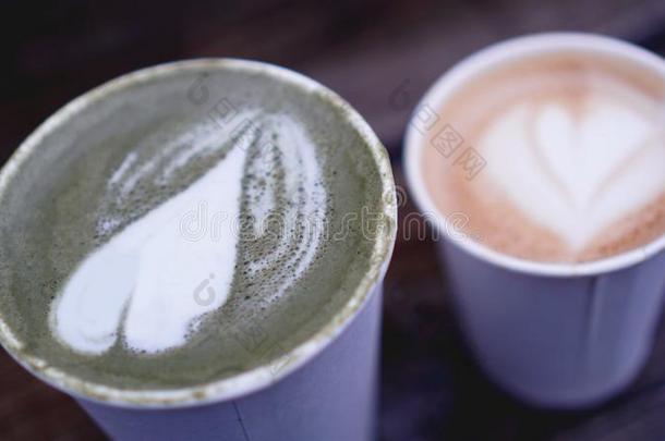 杯子关于日本抹茶茶水和拿铁咖啡和卡普契诺咖啡采用纸杯子向木材