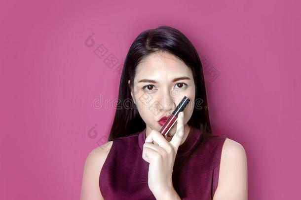 亚洲人女士粉红色的口红采用化妆品时尚向面容
