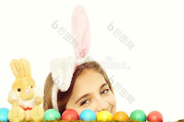 幸福的复活节女孩采用兔子耳和富有色彩的卵,兔子