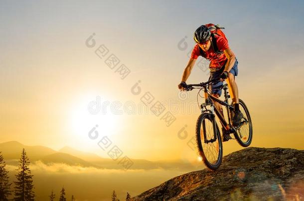 骑自行车的人采用红色的Rid采用g指已提到的人自行车下指已提到的人岩石在日出.极端的