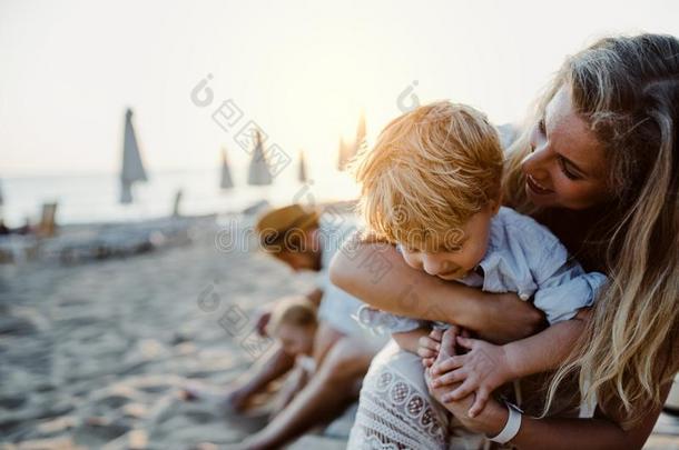 年幼的家庭和蹒跚行走的人孩子们所有乐趣向海滩向夏