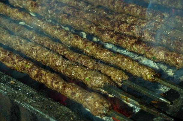 烤腌羊肉串或凯巴普向金属串肉杆烤架和余烬采用指已提到的人烤腌羊肉串