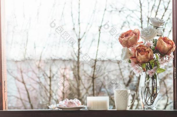 舒适的春季仍生活:杯子关于热的茶水和春季花束关于flores花