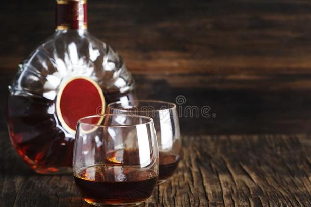 两个眼镜关于白兰地酒的一种和瓶子关于白兰地酒的一种向木制的背景