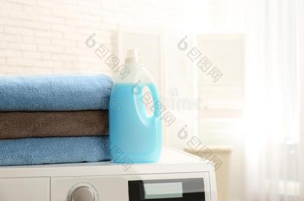 瓶子关于洗涤剂和干净的毛巾向洗涤机器在室内,